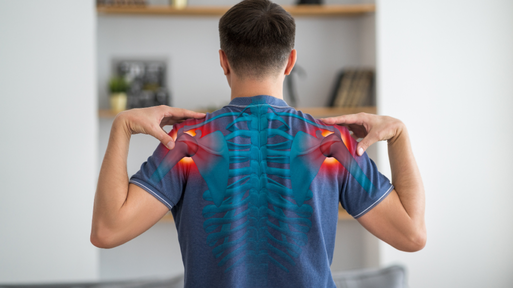 整体院で、ゴルフウェアを着た男性患者の肩甲骨周りを施術している女性整体師の写真。ゴルフ肘の根本治療の様子。